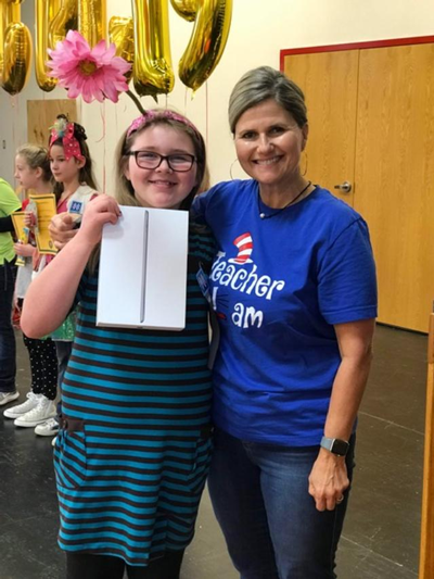 Ms. McEntire with a student who won the Great Reading Games standing together smiling. 